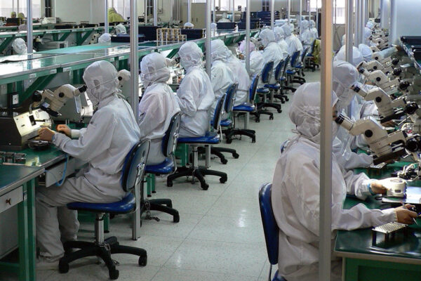 Plenty of workers, no automation needed. Thousands of workers assembling and testing electronics at a factory in China.