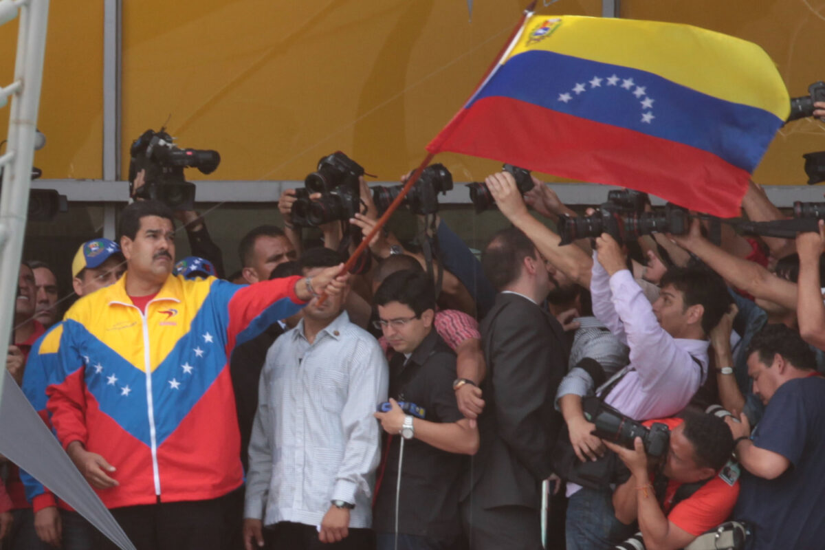 Former bus driver Nicolás Maduro in the spotlight, waving the flag of the country he broke.